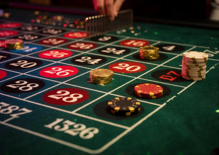 Roulette-Tableau von oben mit Chips auf einer Einzelzahl, einer Split-Wette, einer Eckwette und einer Au&szlig;enwette